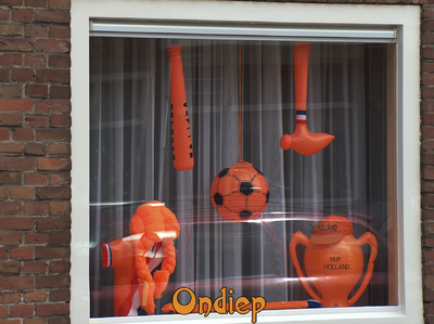 716538 Fotopaneeltje, met een afbeelding van een met oranje artikelen versierd venster in het Ondiep te Utrecht. De ...